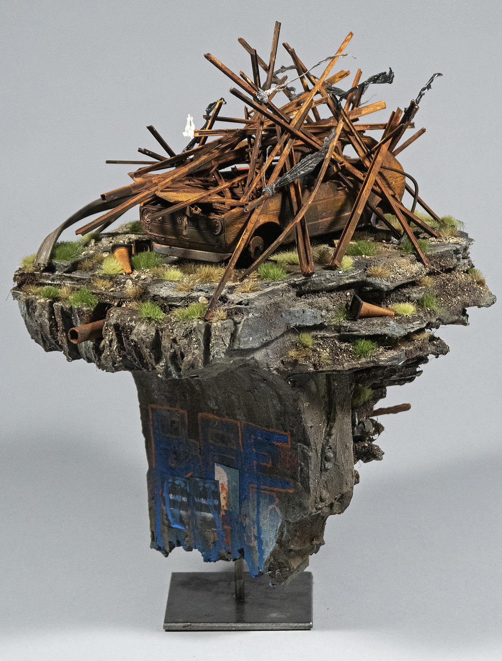 a hand-sculpted miniature by Simon Laveuve of a car and rusty wreckage