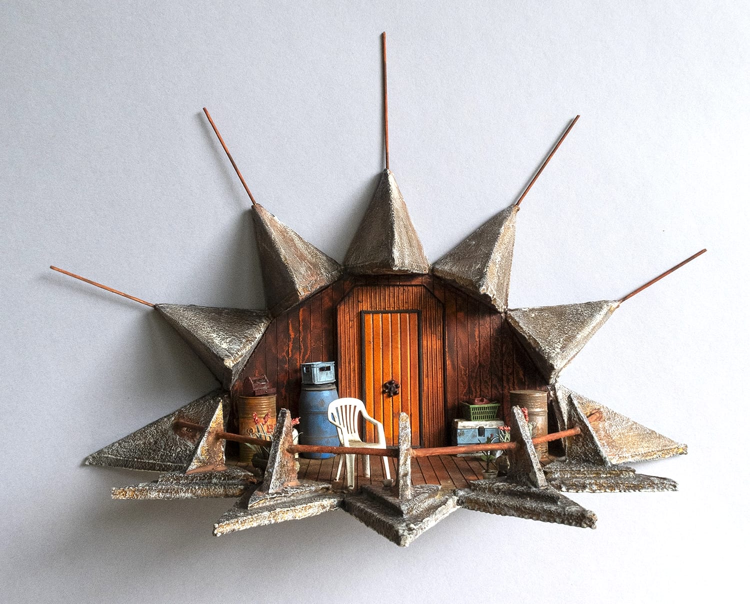 a hand-sculpted miniature by Simon Laveuve of a small room tableau with geometric rays pointing off in all directions