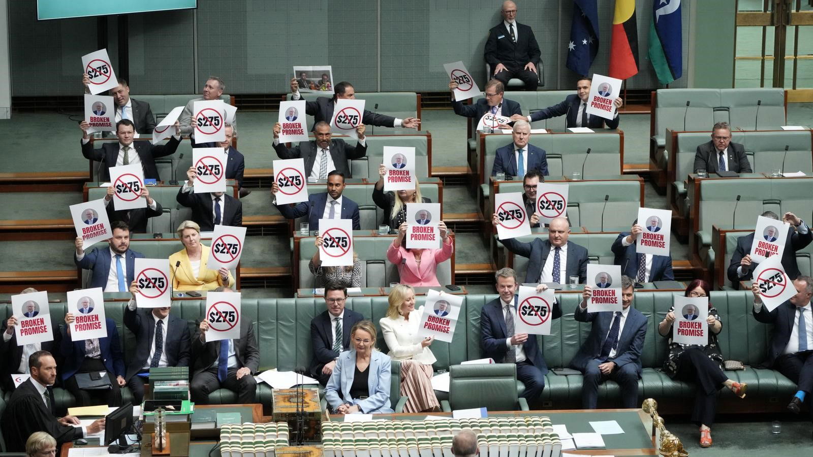 The opposition hold up signs in the house of representatives.