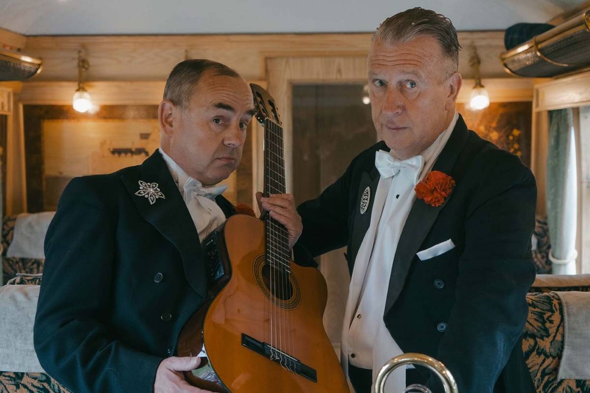 Musicians holding up a classical guitar
