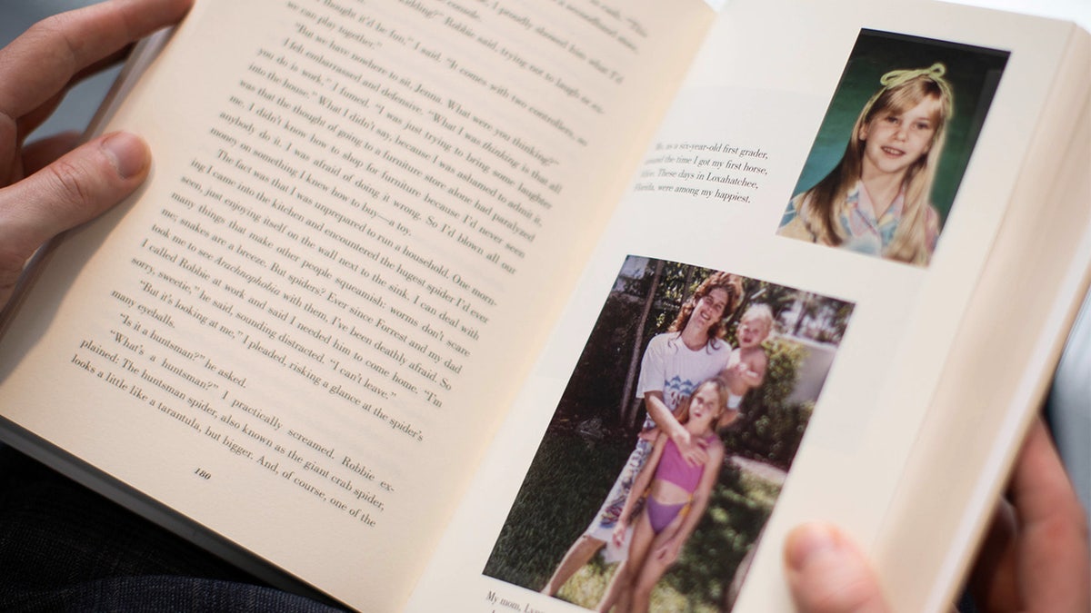 A person reads a copy of Nobody's Girl by Virginia Giuffre