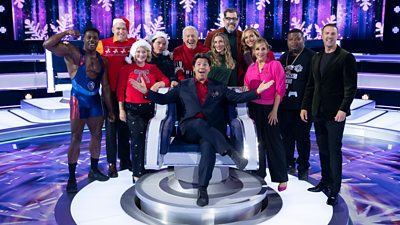 Michael McIntyre sits the big revolving contestant chair on The Wheel surrounded by his festive contestants and experts