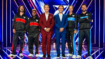 Four Celebrity contestants tracksuits stand either side of hosts Bradley and Barney Walsh in the Gladiators arena