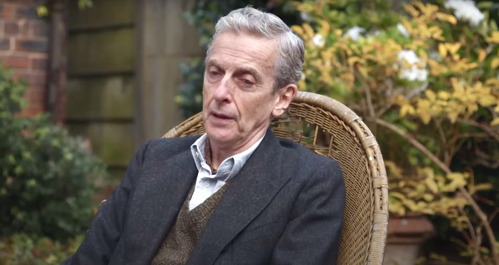Peter Capaldi, Benediction peter capaldi sitting in a chair in a garden in benediction, an older gentleman with grey hair wearing a white shirt, brown jumper and grey jacket