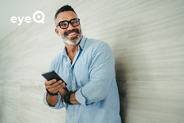eyeQ a man holding his smartphone and smiling
