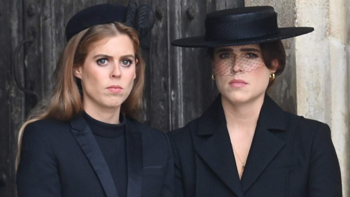 Princes Beatrice and Princess Eugenie wearing matching black attire.