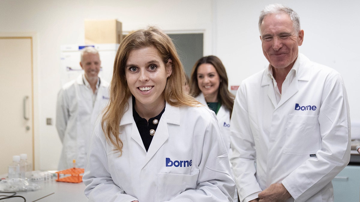 Princess Beatrice smiling in a lab coat.