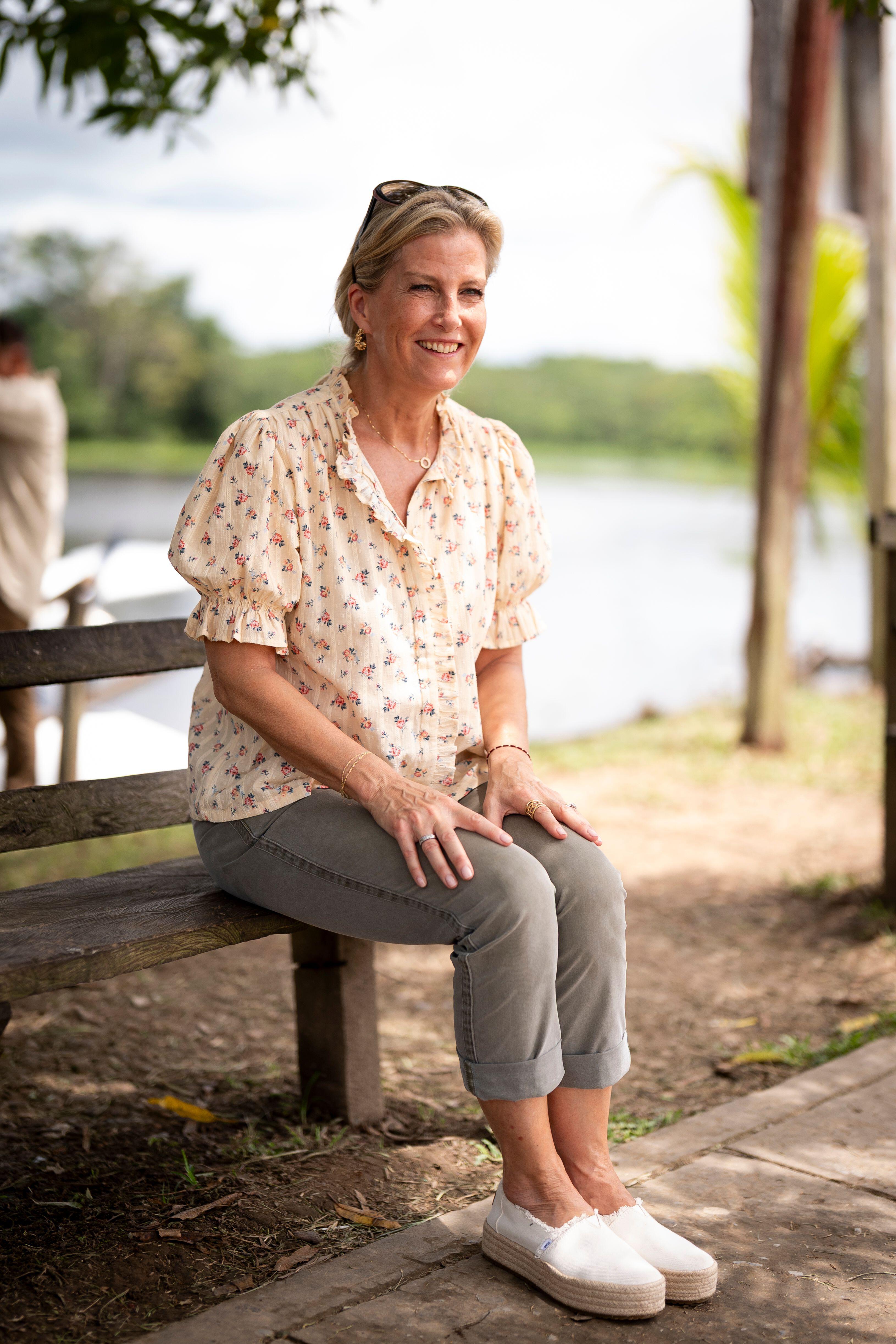 Duchess Sophie sitting on a bench wearing a floral top and gray pants