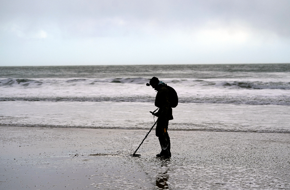 A man on a beach with a metal detector