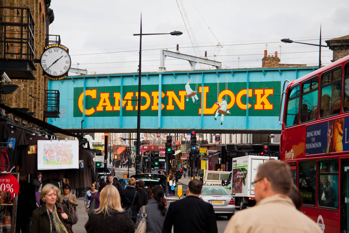 crowds of people on camden high street with the iconic camden lock artwork visible above them