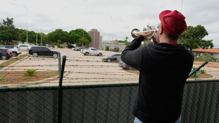 A trumpeter plays a funeral march outside police headquarters to celebrate the arrest. Pic: AP