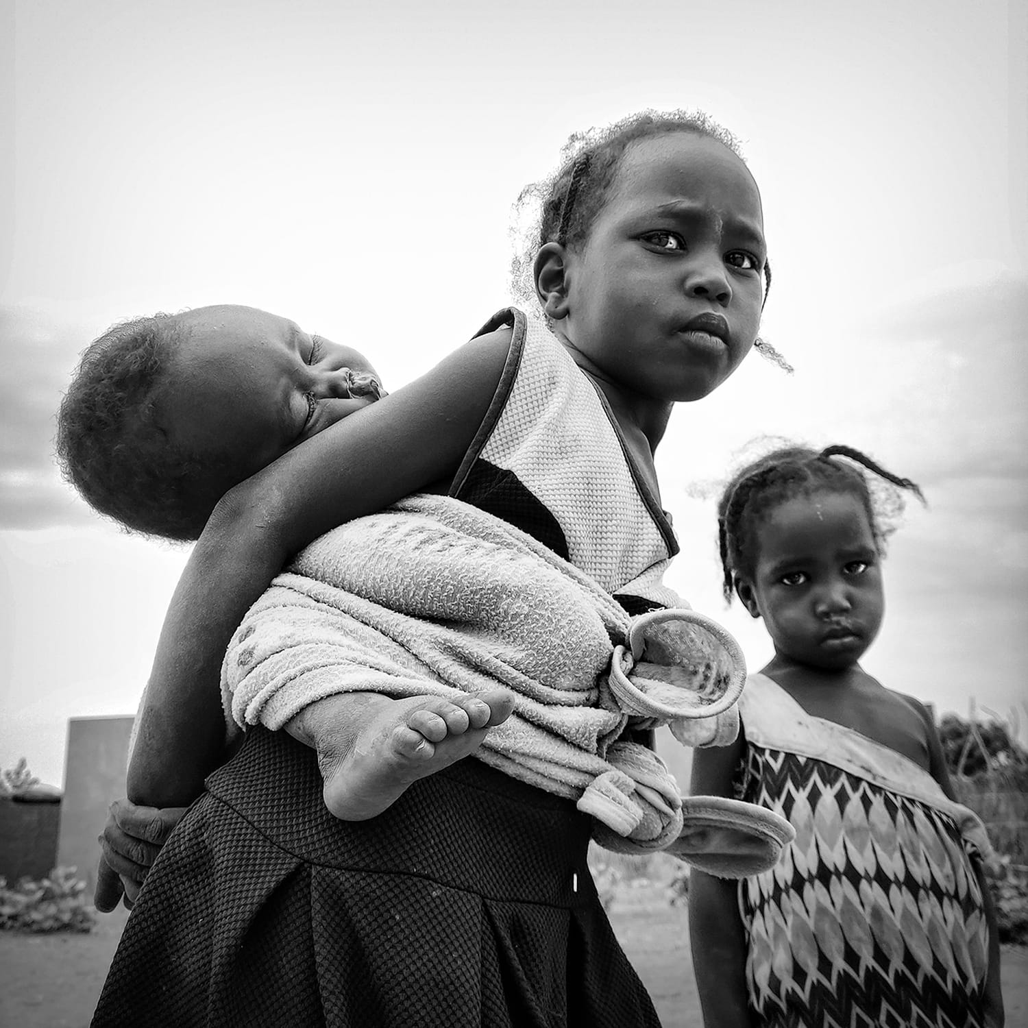 a black-and-white photograph by Mawran Mohamed of three children playing