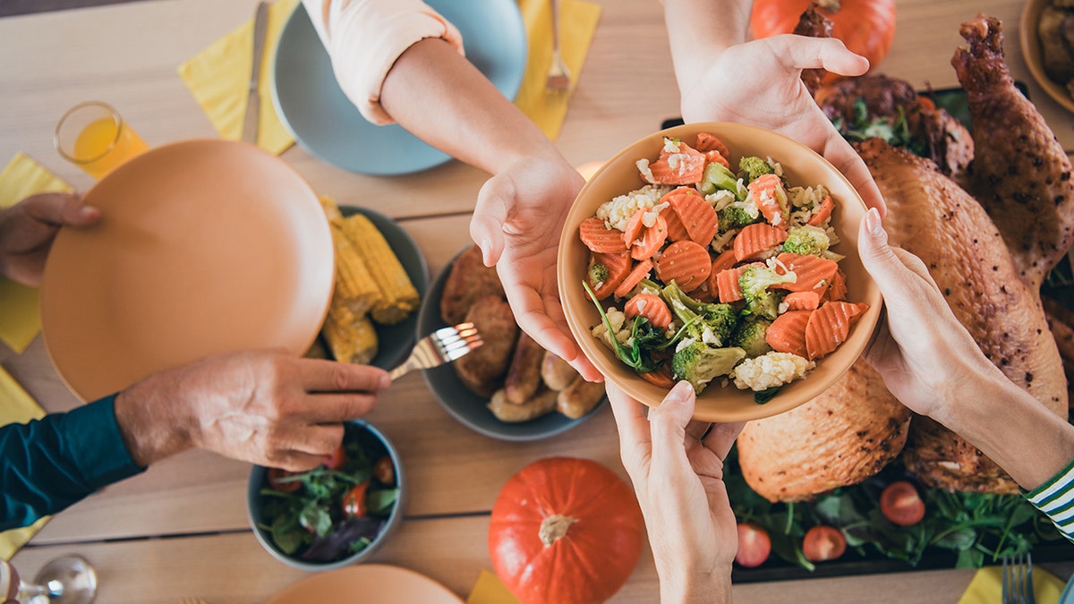 People passing salad at Thanksgiving table