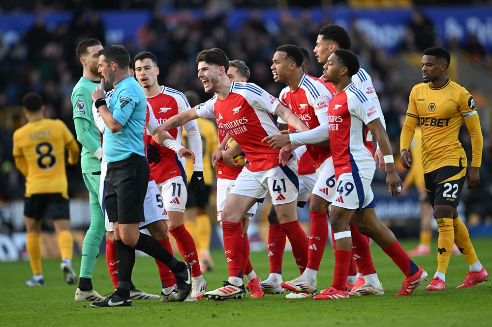 WOLVERHAMPTON, ENGLAND: Declan Rice of Arsenal and his teammates protest to Referee Michael Oliver after Myles Lewis-Skelly of Arsenal is shown a red card for a foul on Matt Doherty of Wolverhampton Wanderers (not pictured) during the Premier League match between Wolverhampton Wanderers FC and Arsenal FC at Molineux on January 25, 2025. (Photo by Shaun Botterill/Getty Images)