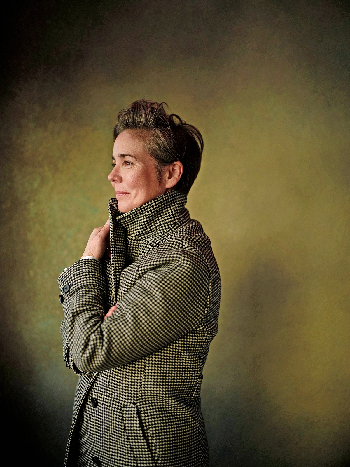 Georgi Banks-Davies looking to the left, wearing a houndstooth coat.