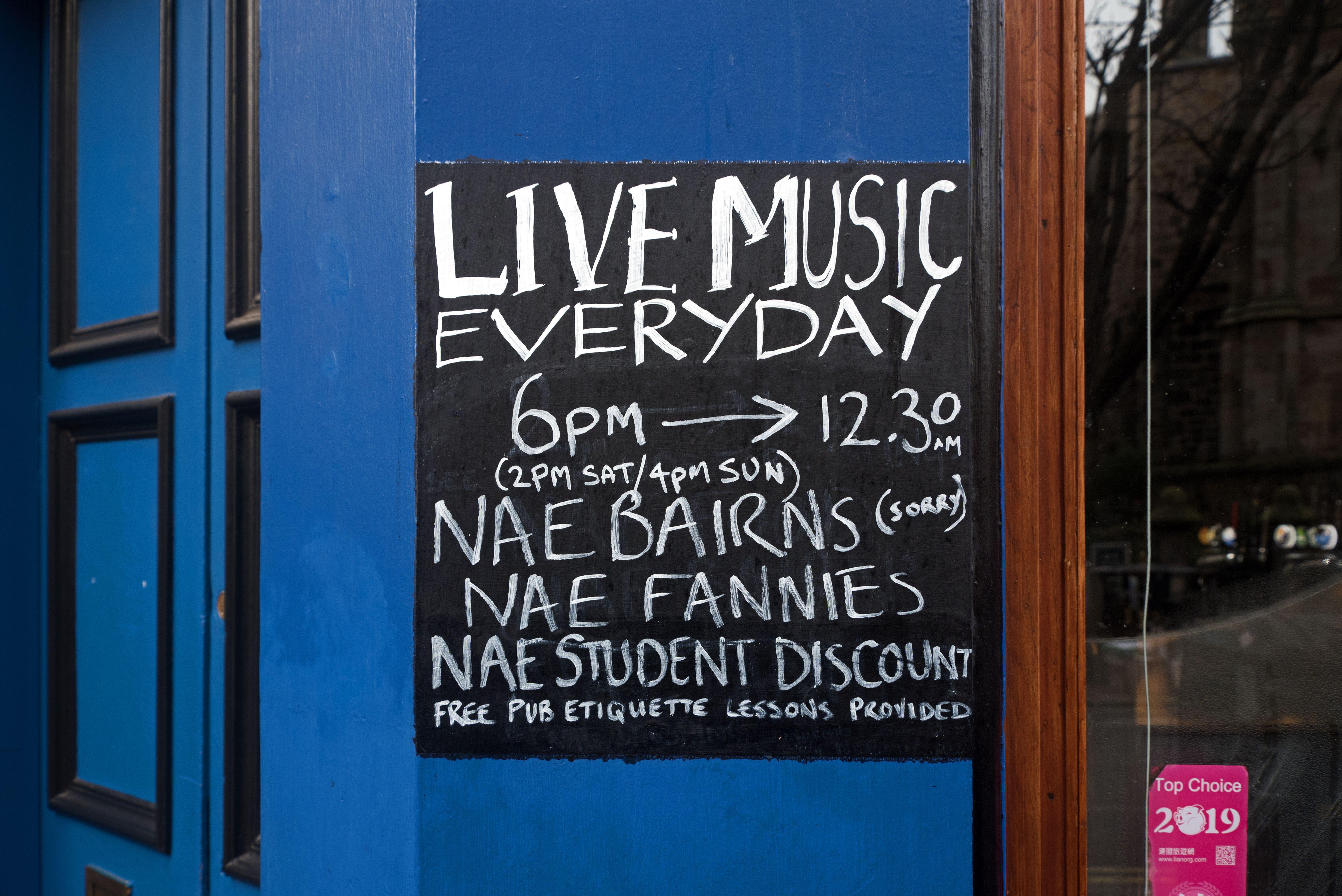 Sign in Scottish dialect for Sandy Bell's bar advertising live music, no children ("nae bairns"), no fannies, and no student discount.