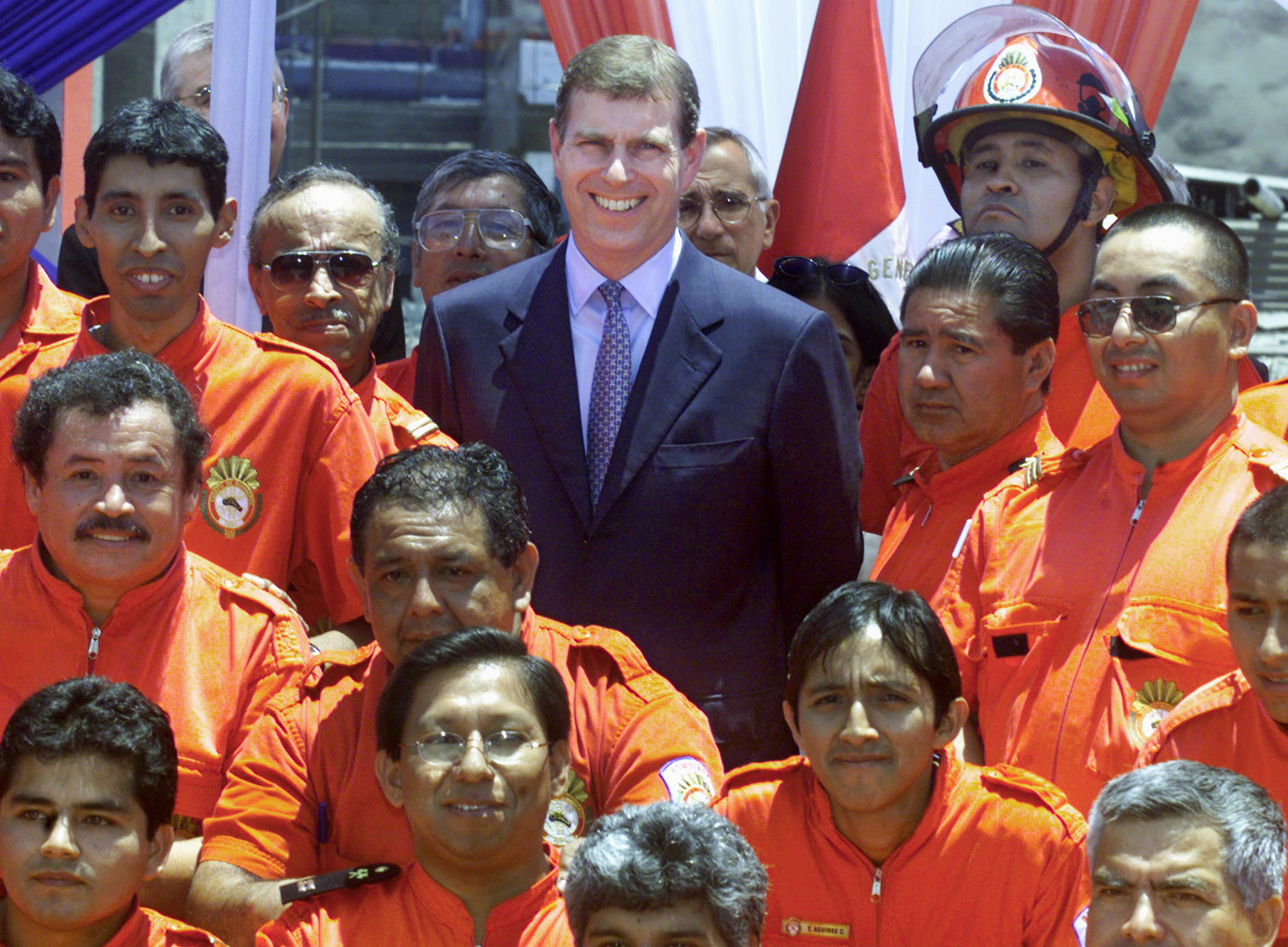 Prince Andrew posing with a group of firefighters at a Lima fire station.