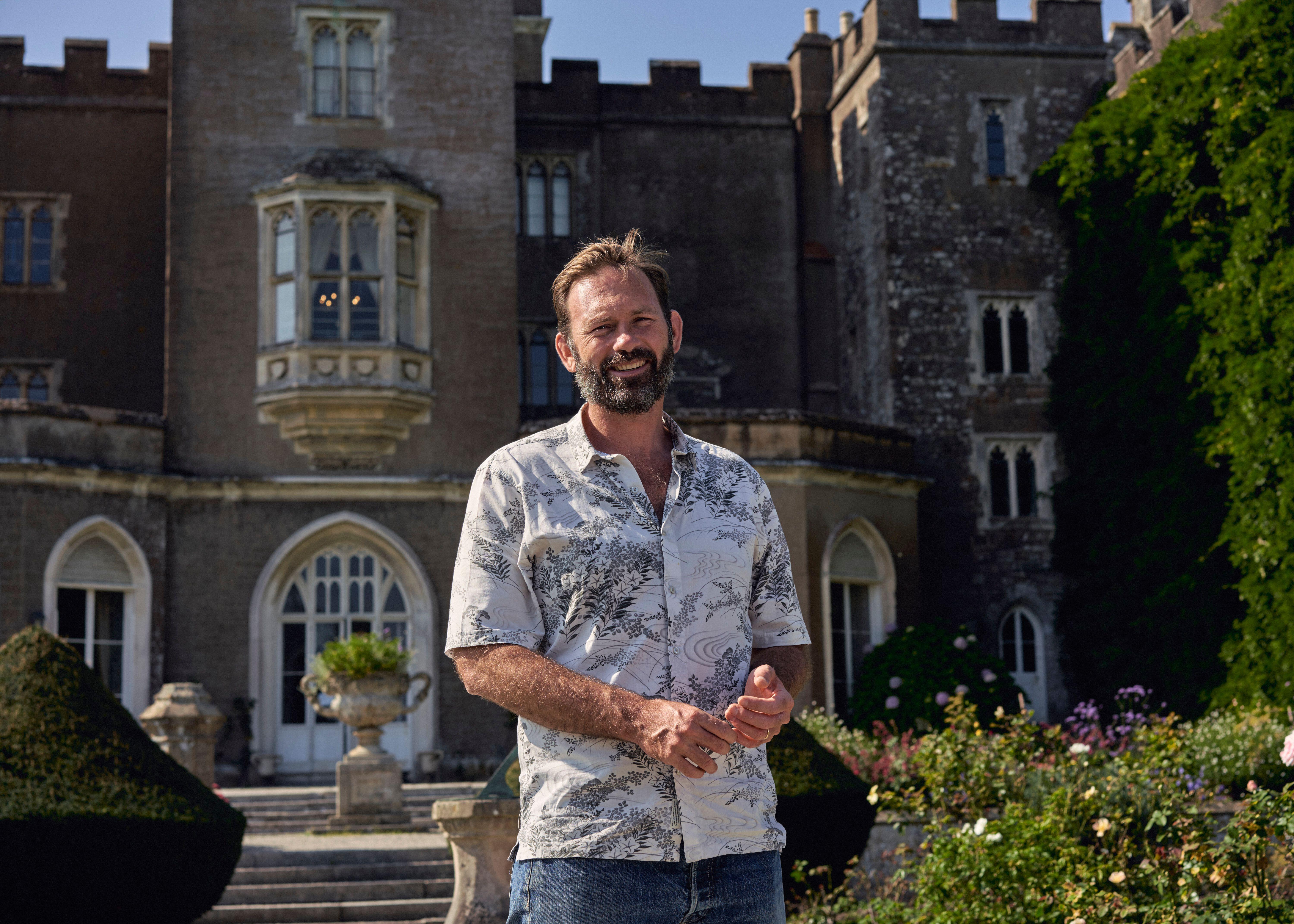 Charles Courtenay, the 19th Earl of Devon, standing in front of Powderham Castle.