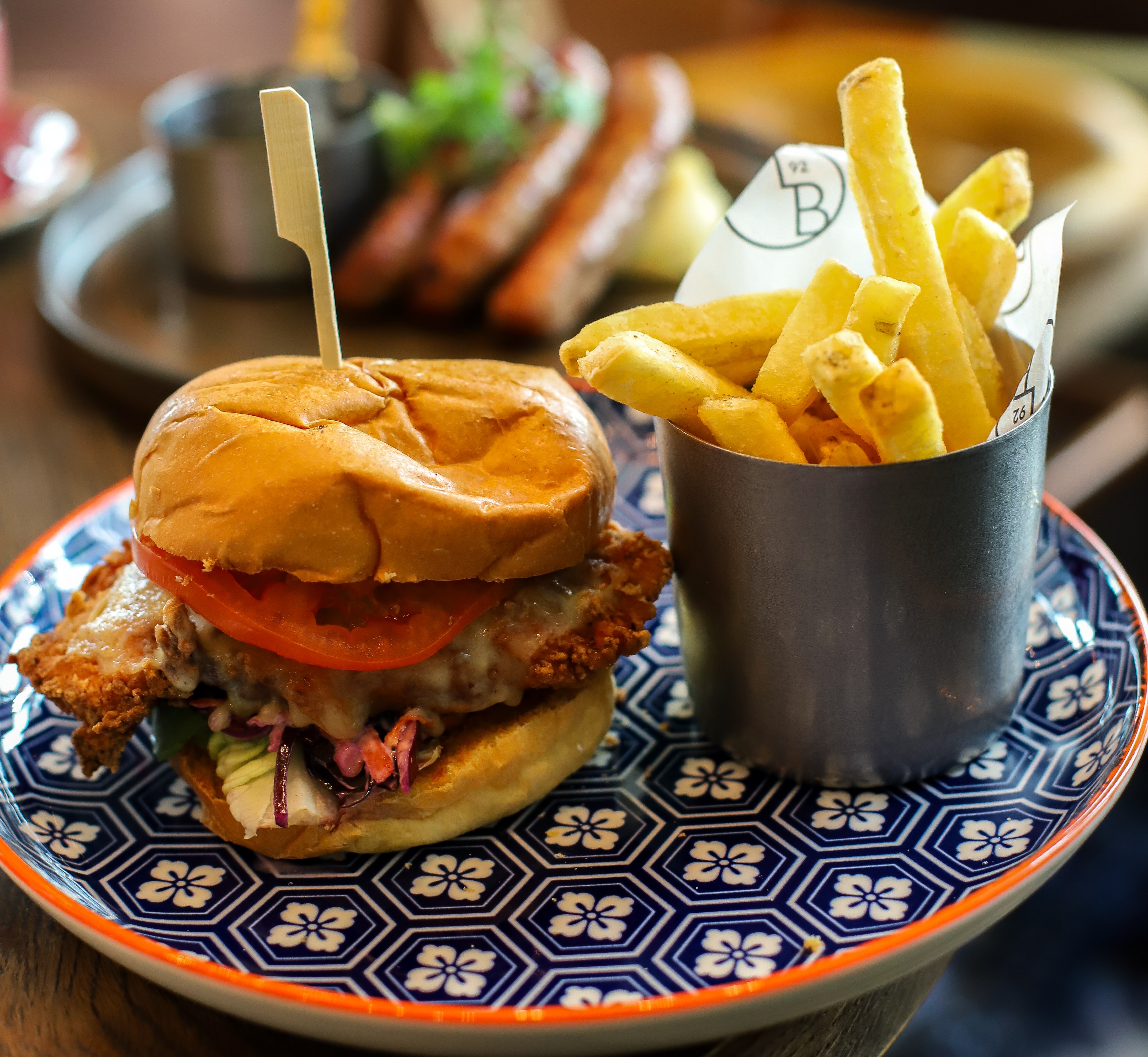 Burger and fries on a blue and white patterned plate.
