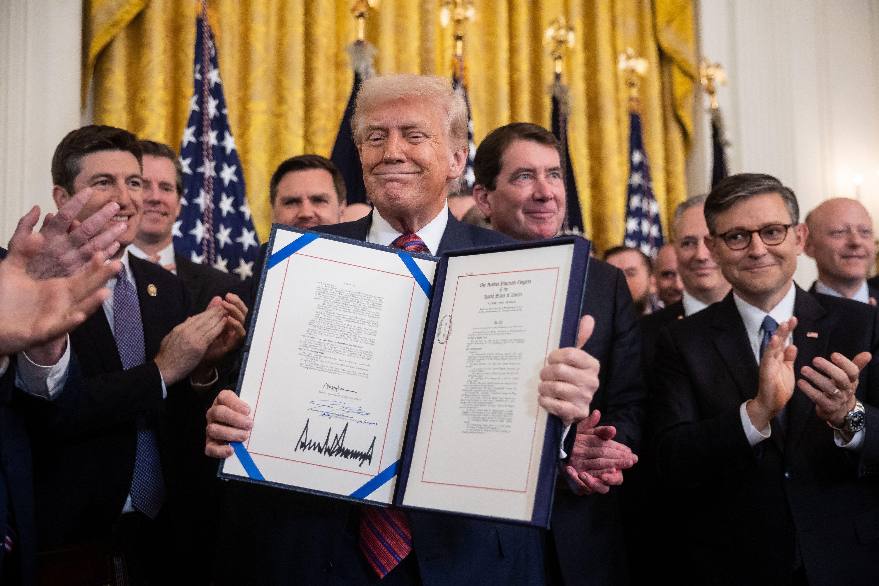 Donald Trump signing the S.1582 GENIUS Act, a crypto bill, in the East Room of the White House.