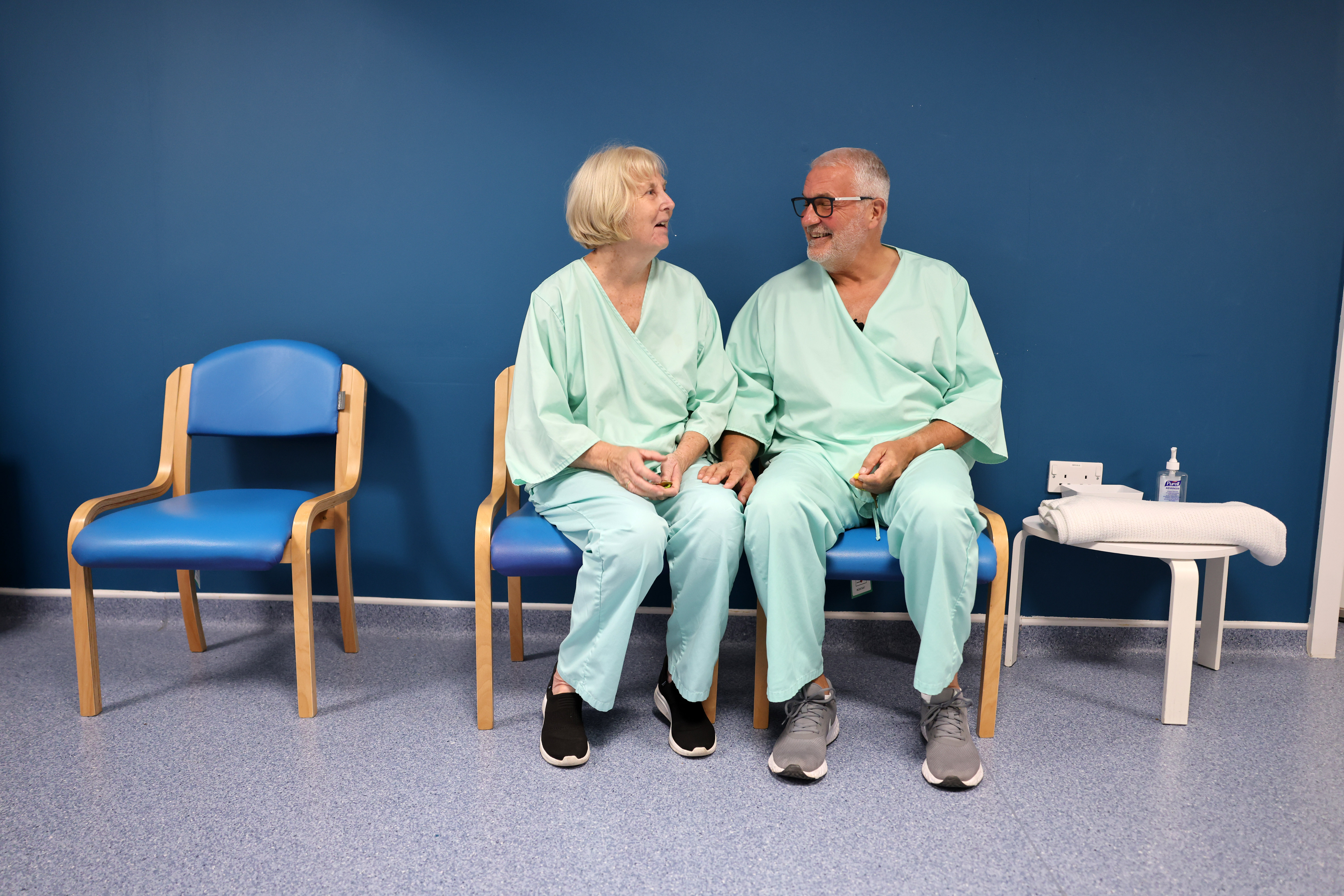 Stephen and Lesley Crossley, a married couple, sit together in medical gowns at the Biobank imaging assessment centre.