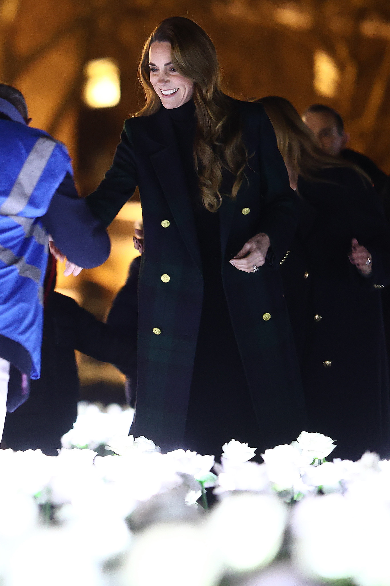 The Princess of Wales smiles as she shakes hands with someone at the Ever After Garden.