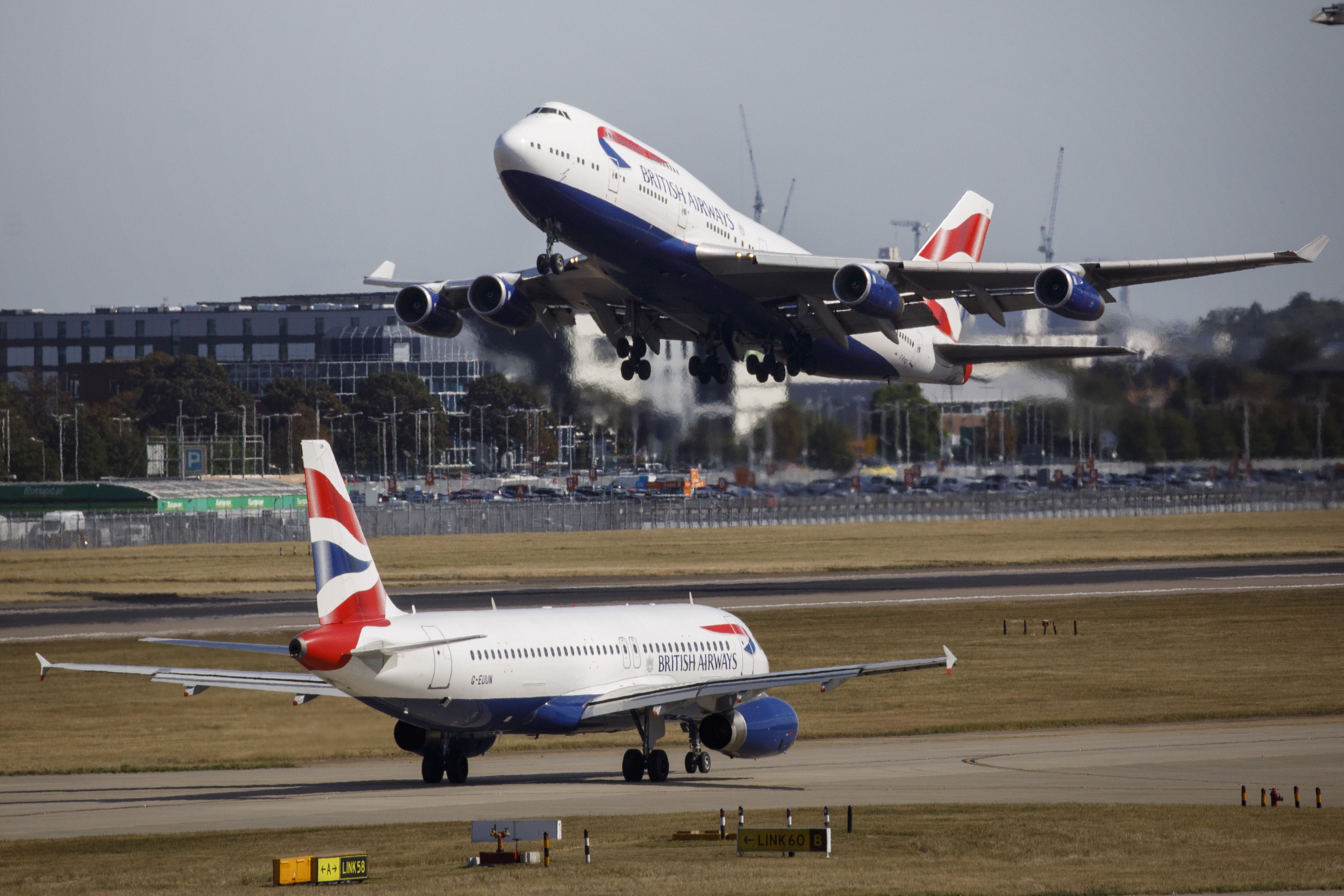 A British Airways aeroplane taking off from Heathrow Airport's Terminal 5 with another British Airways plane on the runway.