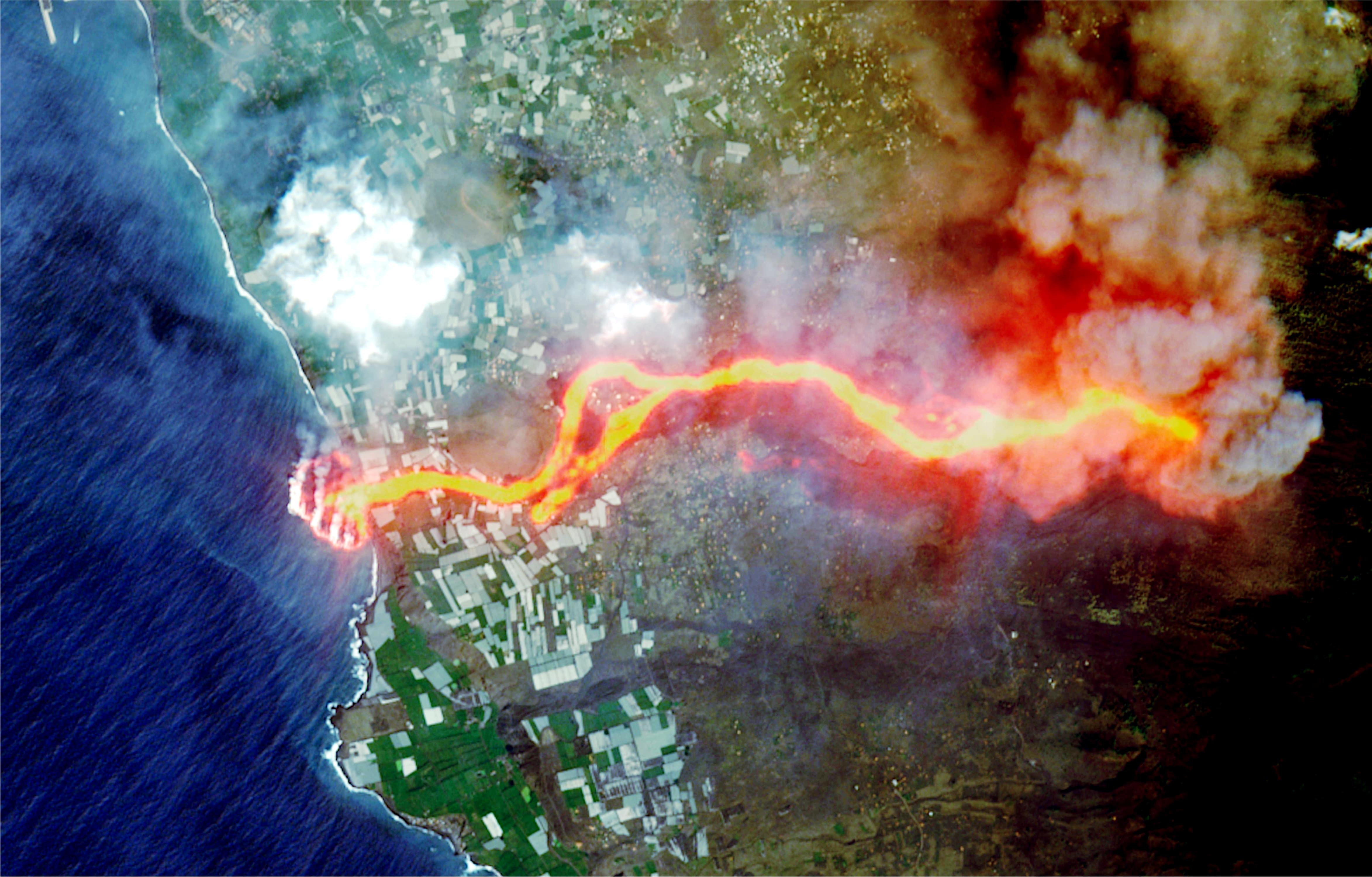 Satellite image of lava flow from a volcano on La Palma island reaching the ocean.