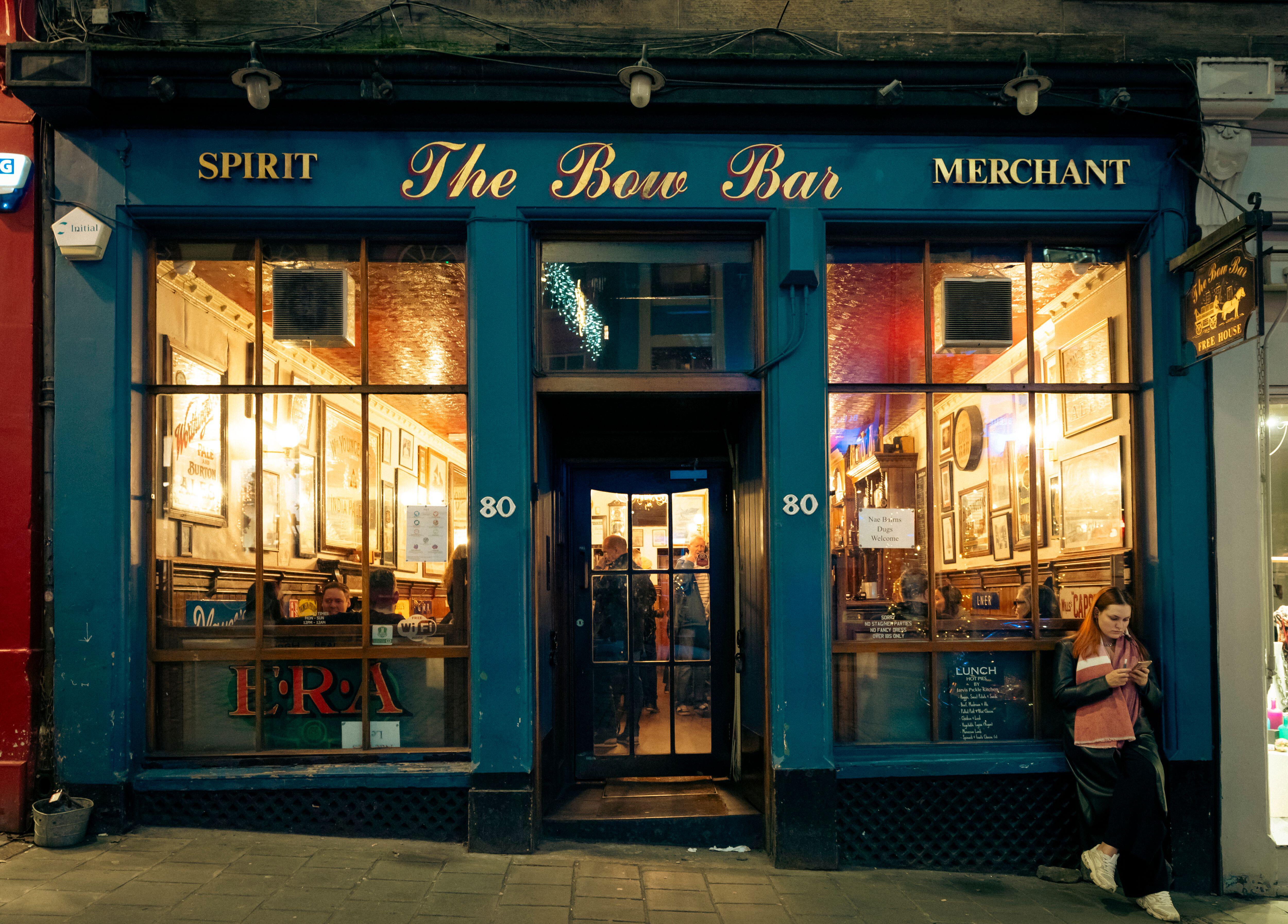 The exterior of The Bow Bar at night on Victoria Street in Edinburgh Old Town, Scotland, UK.