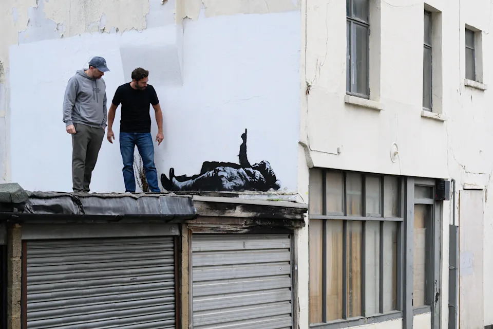 Two men look at a new Banksy artwork on Dec. 22, 2025 in London, England.  / Credit: Leon Neal/Getty Images