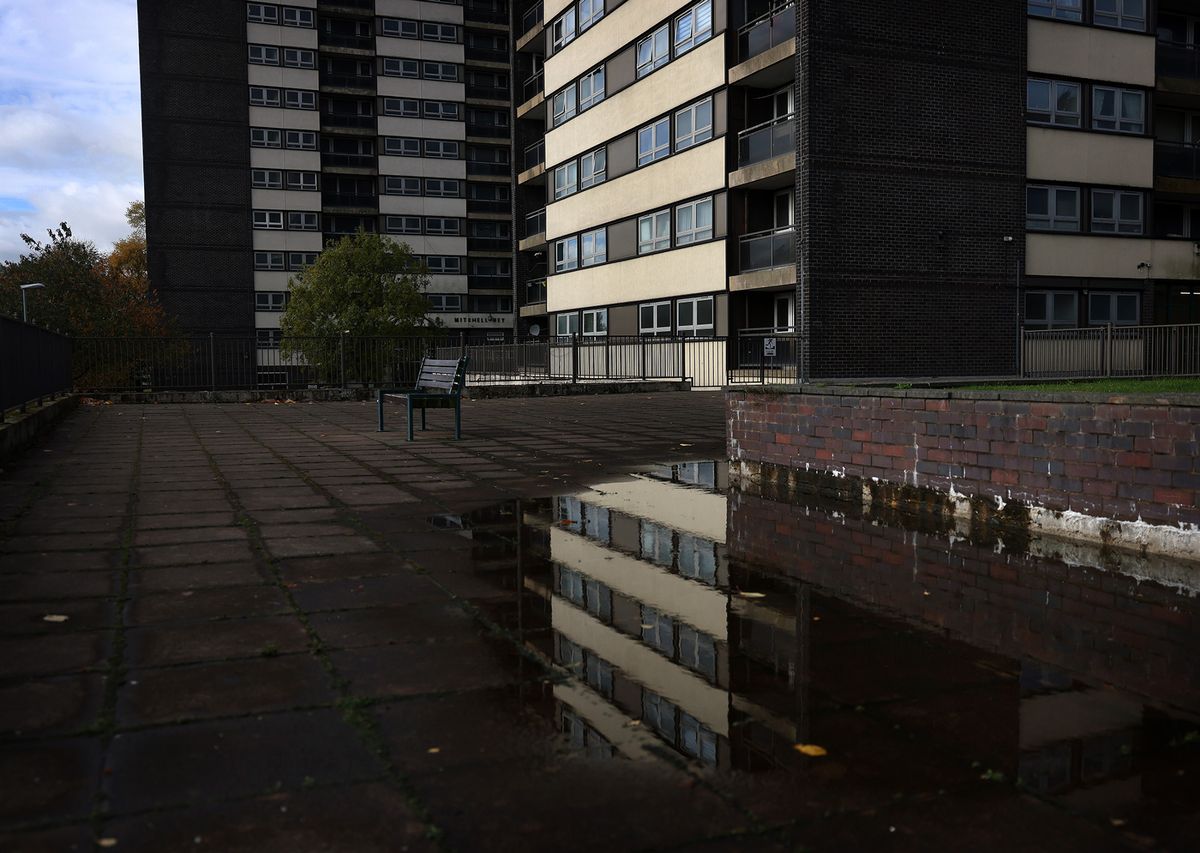 The Seven Sisters tower blocks in Rochdale, seen through the reflection of a puddle