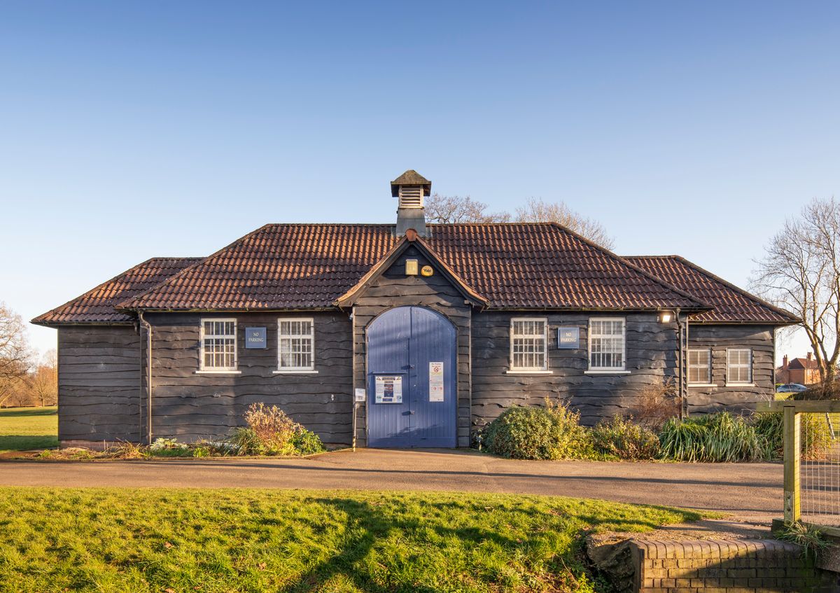 Bournville Radio Sailing and Model Boat Club Boathouse and associated concrete boating pond, Valley Parkway, Bournville, Birmingham, West 
Midlands.
General view of boathouse built in 1933 by the Cadbury family, designed for the storage of model boats and facilities for boat club members, clad in tarred rustic elm weatherboarding with a hipped pantile roof on which is a central, squared, louvred cupola, with a pyramidal roof, also pantiled. View from north west.