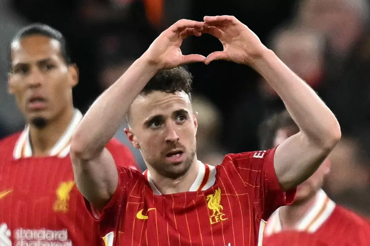Liverpool's Portuguese striker #20 Diogo Jota (2L) celebrates scoring the opening goal during the English Premier League football match between Liverpool and Everton