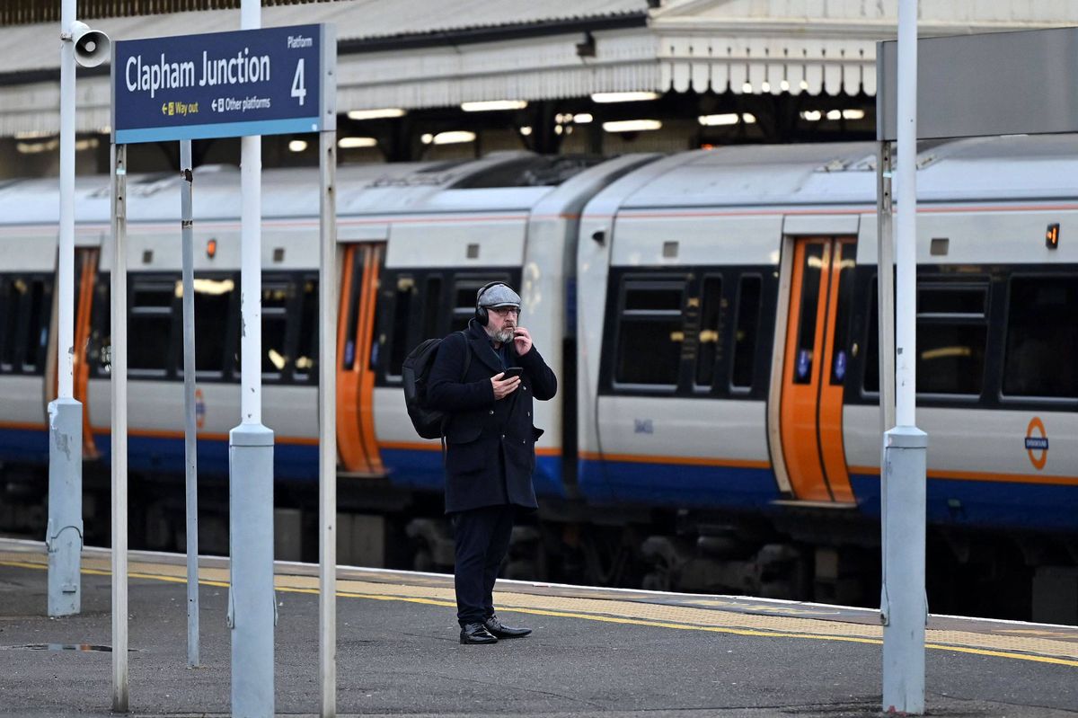 A commuter waits for a train at Clapham Junction station in South London