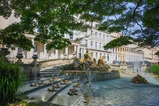 The famous Neptune Fountain which sits outside the Municipal Buildings on The Promenade in the town of Cheltenham in The Cotswolds on a sunny October day
