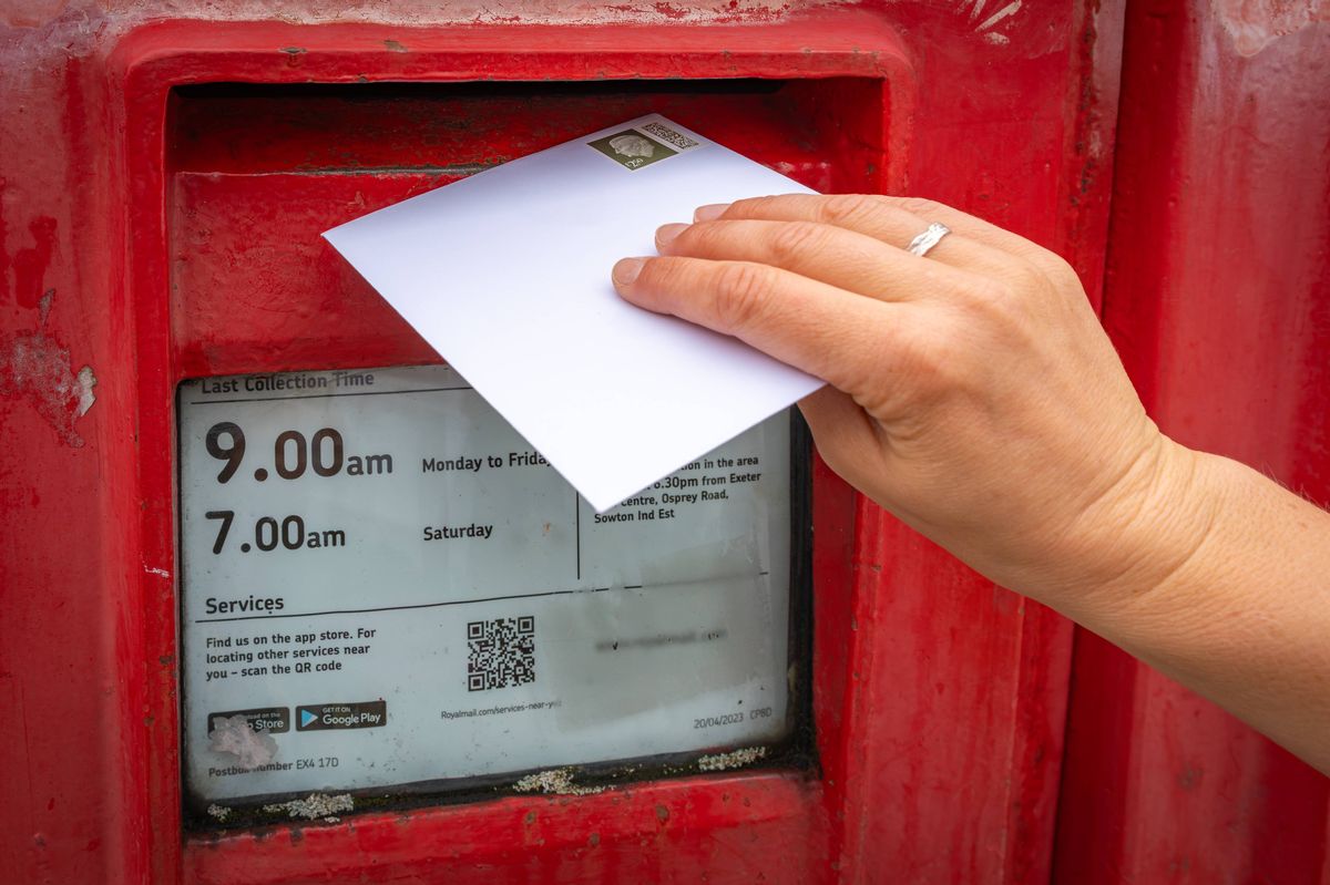 Posting a Letter to a Classic Red British Post Box