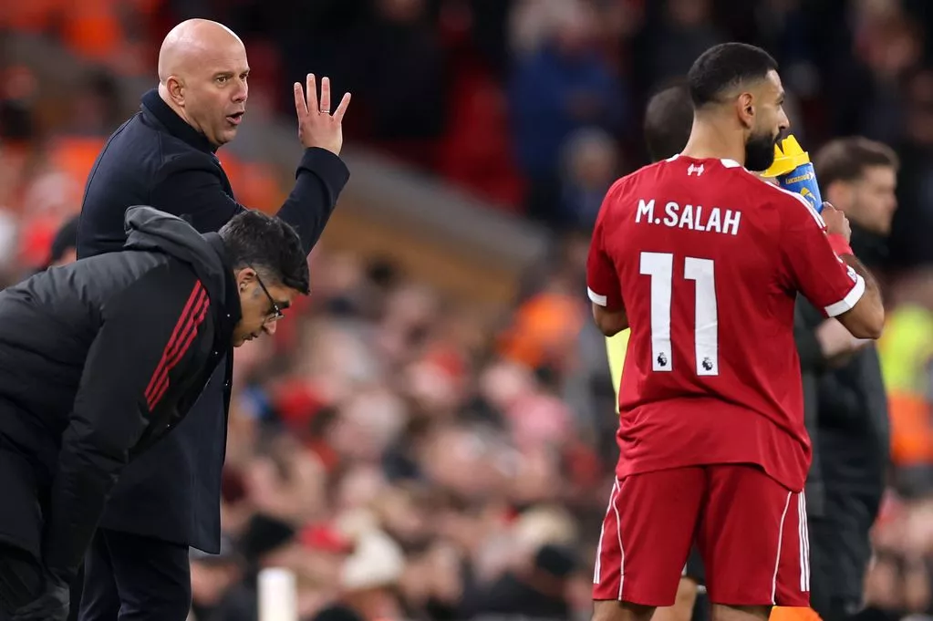 Arne Slot delivers instructions to Mohamed Salah on the sideline during Liverpool's game against Brighton