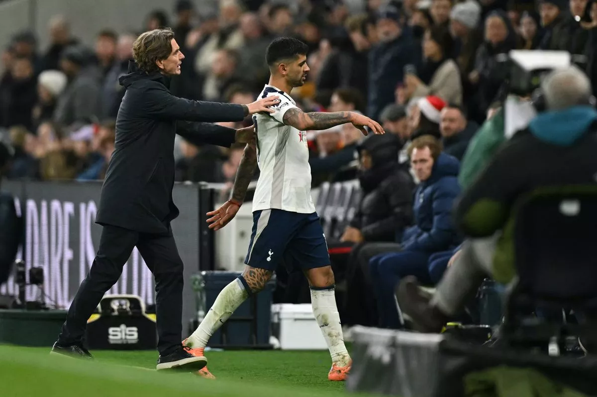 Cristian Romero is ushered off the pitch by Thomas Frank after becoming the second Tottenham player sent off during the Premier League match against Liverpool