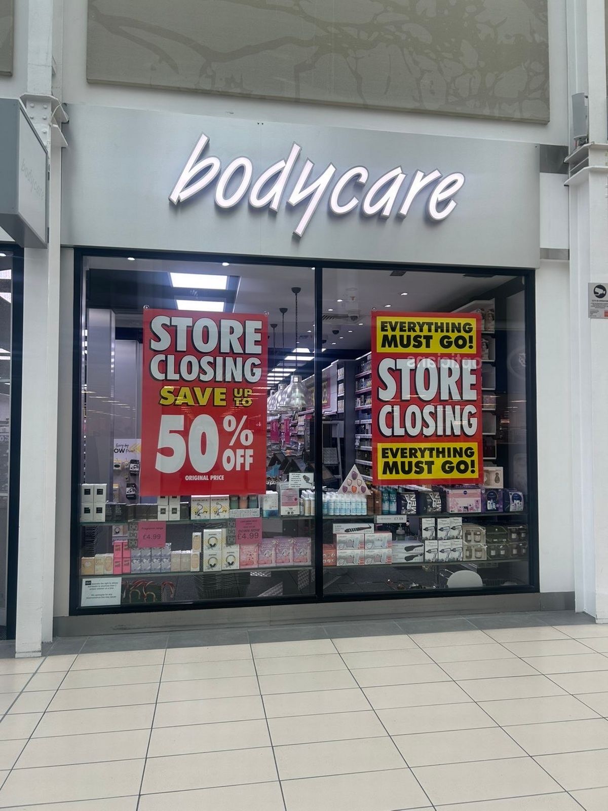 Posters in the windows of Clayton Square's Body Care