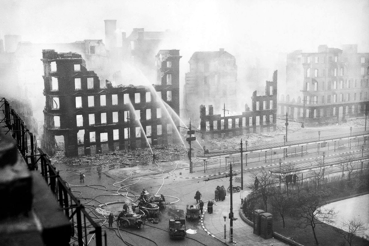 Firemen spray water on to the smouldering remains in the centre following the Christmas Blitz bombing raids in December 1940