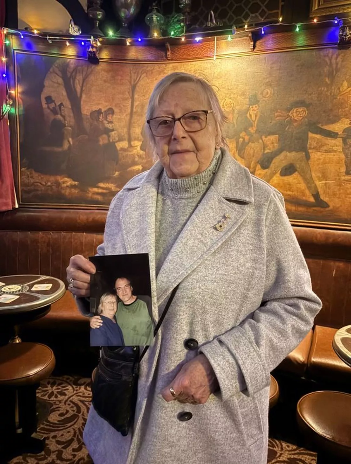 Rita Smith holds up a photo taken when Quentin Tarantino had a drink in Peter Kavanagh's 