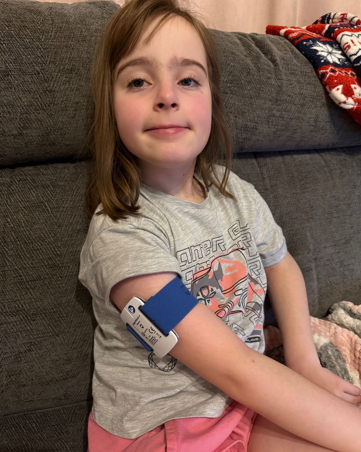 A little girl with a monitor around her upper arm