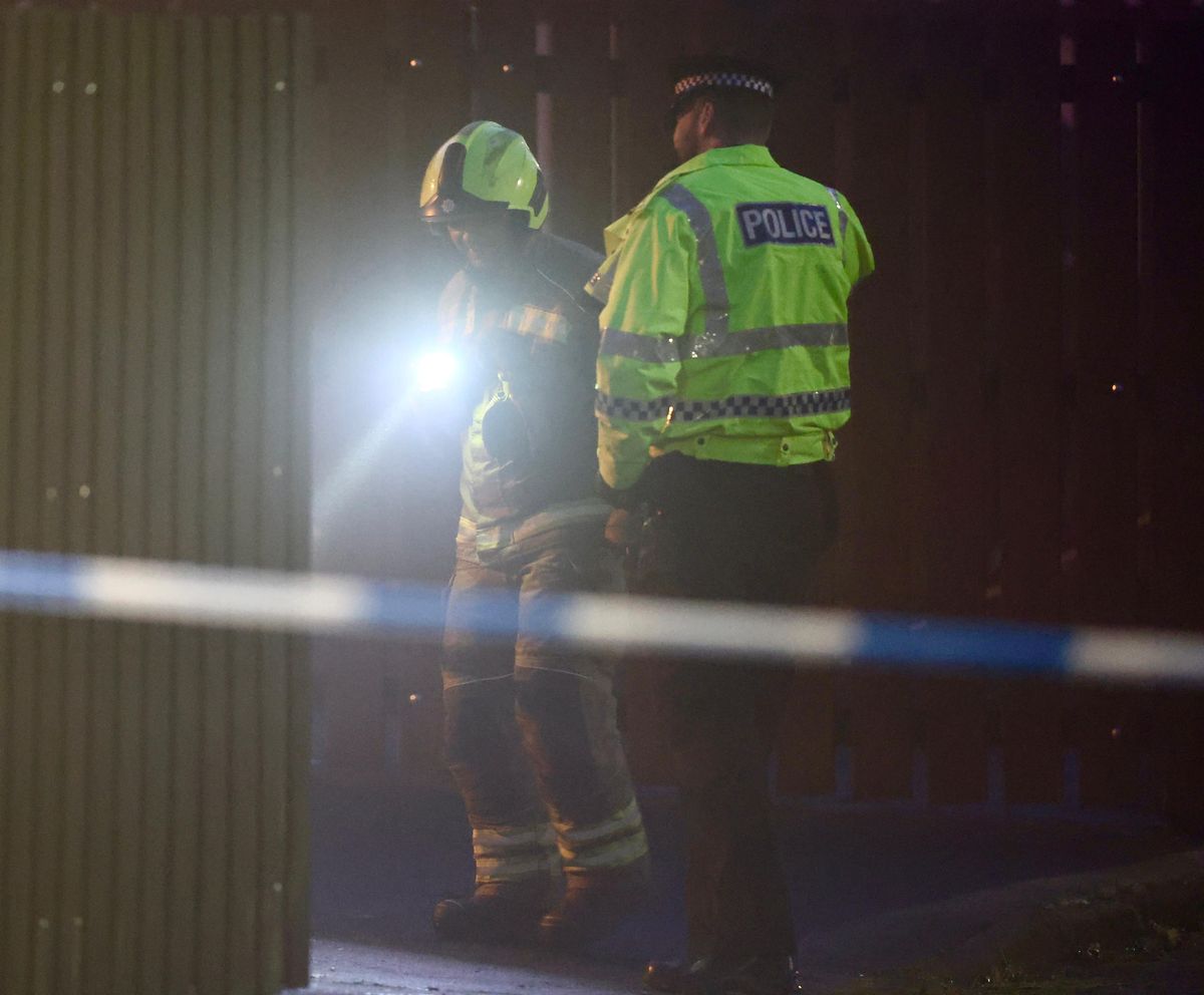 A firefighter at the scene with a police officer. 