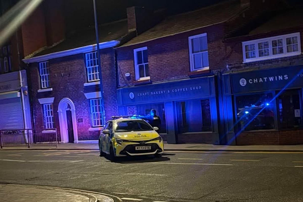Police at a scene in Prescot town centre this evening