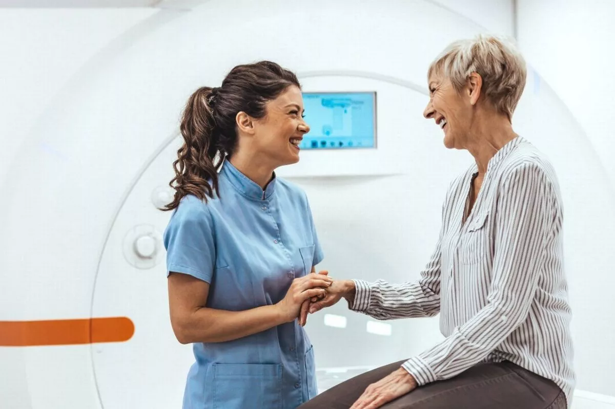 A nurse and woman in front of an MRI machine