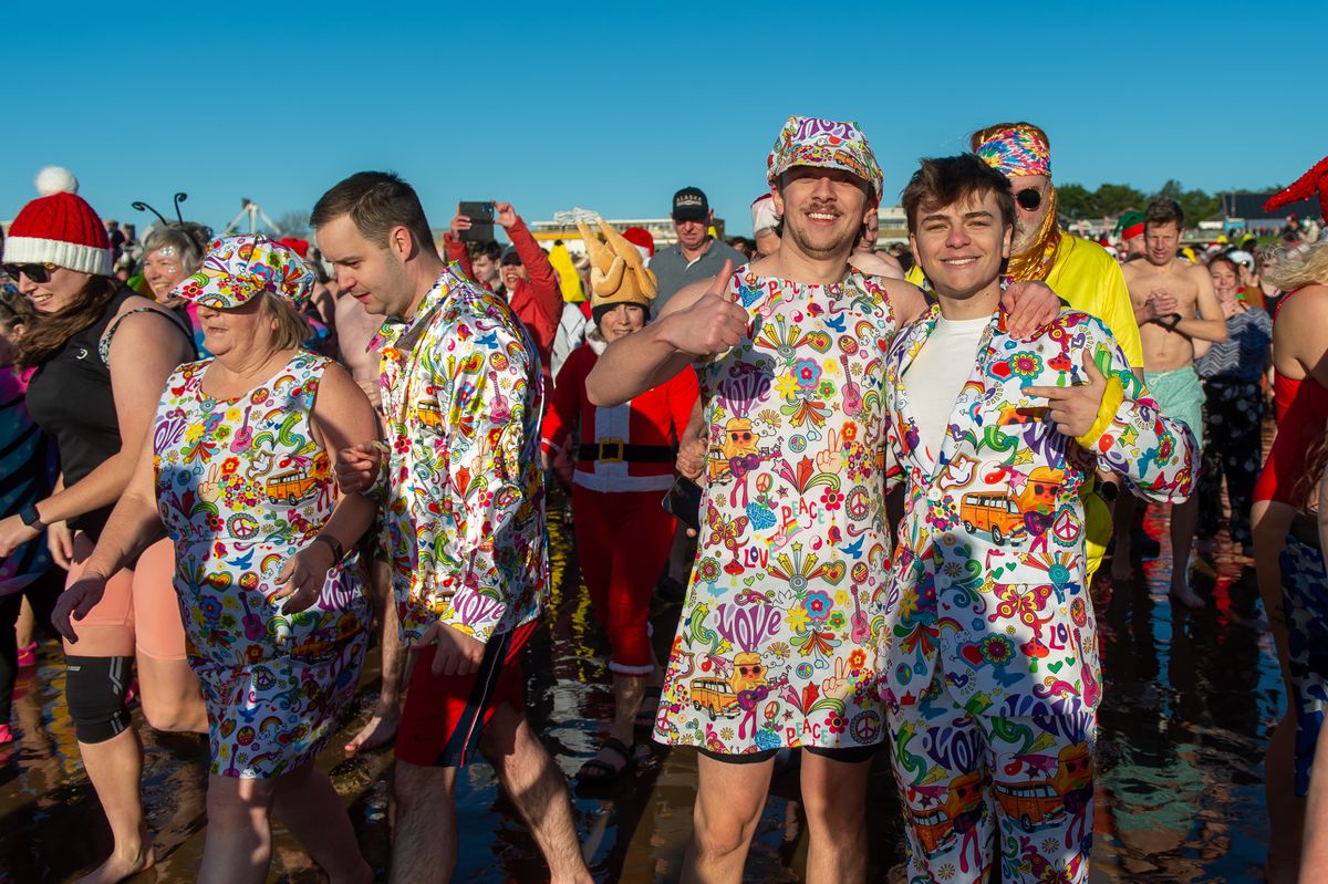 The image shows people in festive dress at the beach 