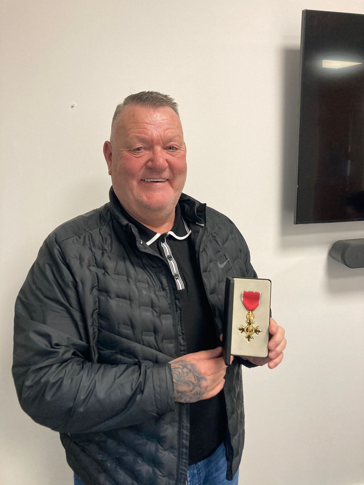 Mark King proudly shows off his OBE