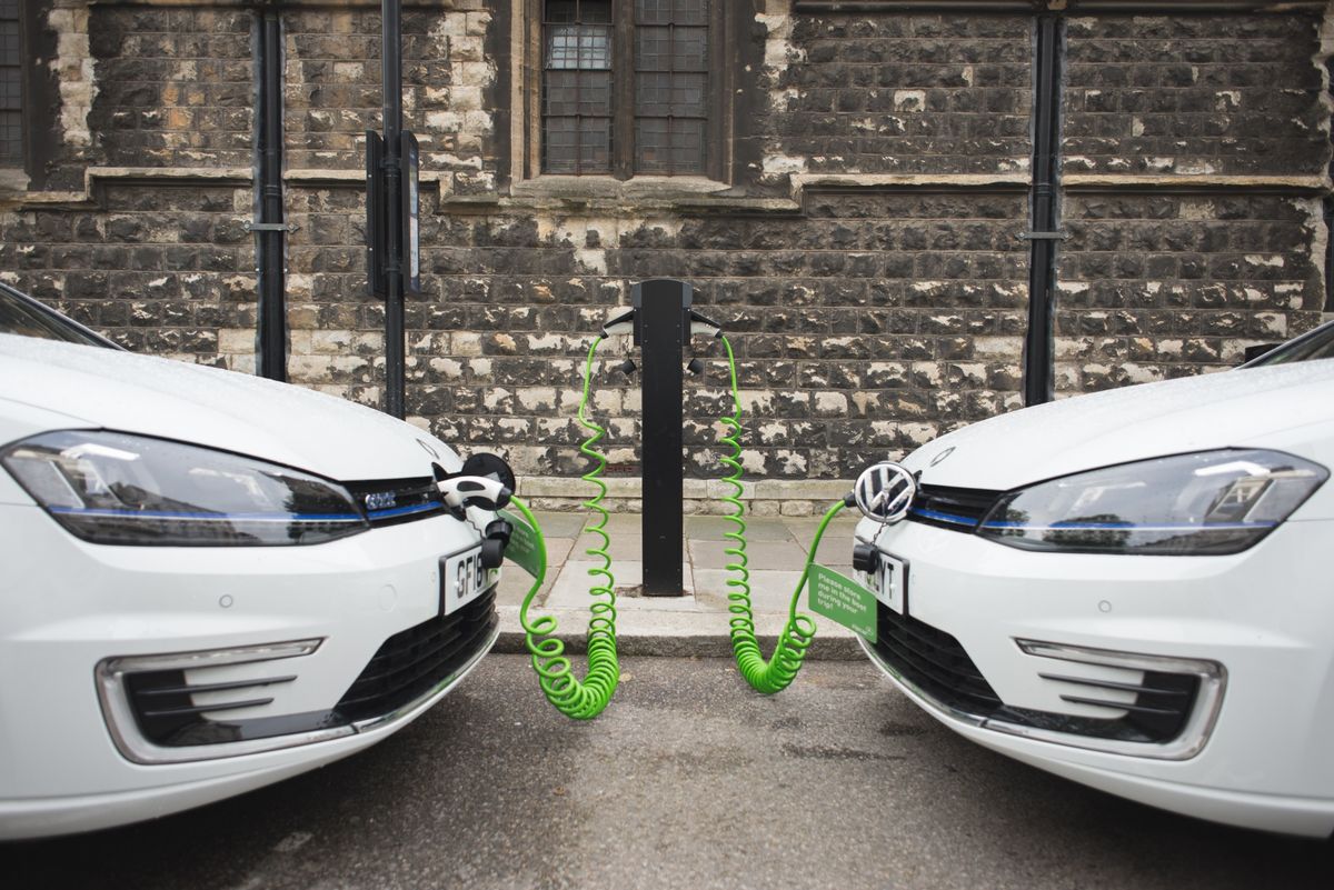 Two electric vehicles charging on the street