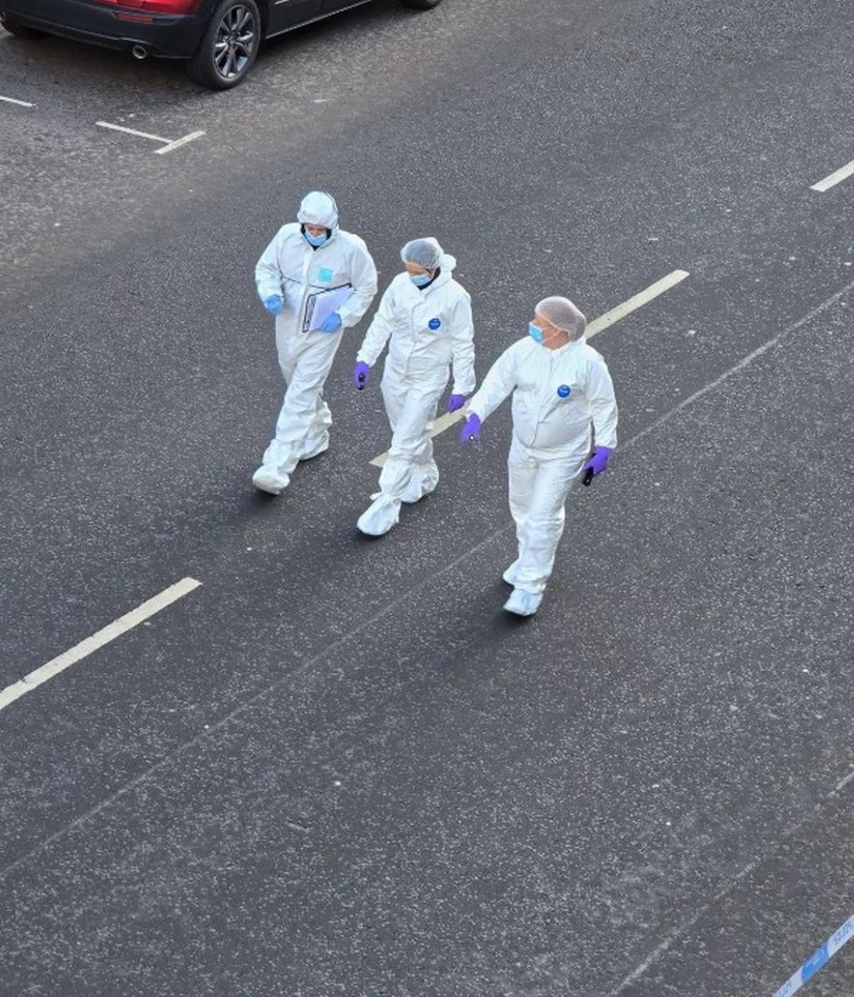 Forensic teams have been pictured scouring a Glasgow street following a death on Christmas Day