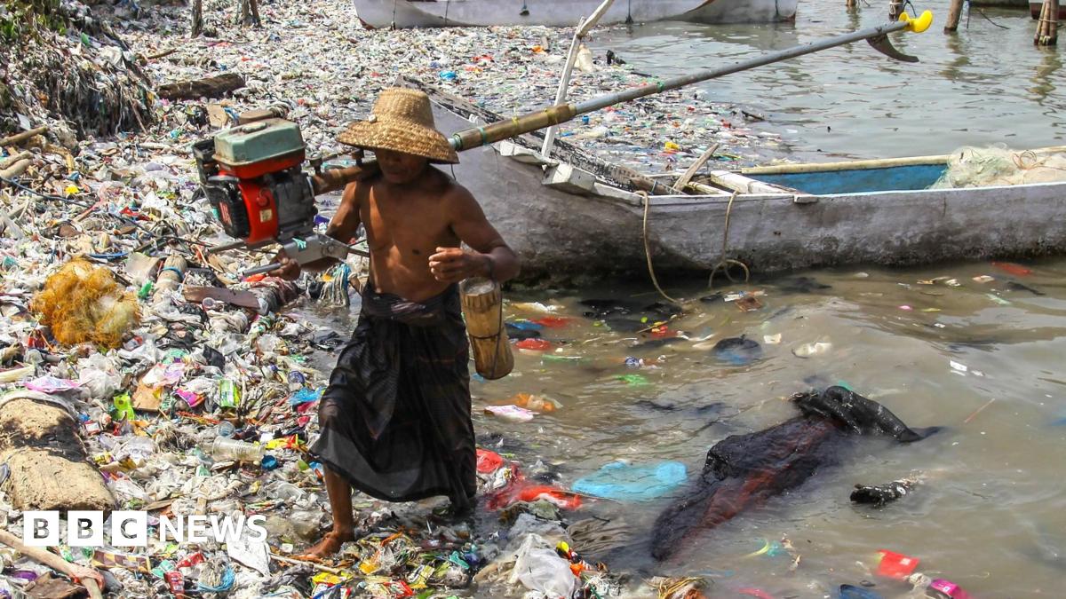 A fisherman arrives at the beach full of rubbish that mostly consists of plastics thrown by local residents and brought by sea currents from various locations in the Kwanyar district, Bangkalan, Madura Island of Indonesia